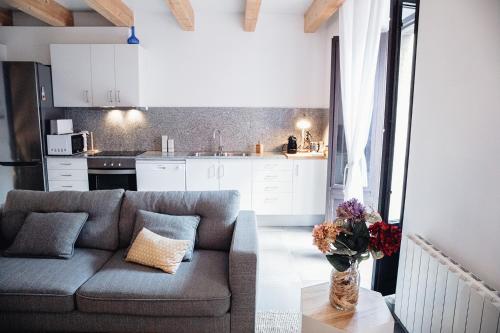 uma sala de estar com um sofá e uma cozinha em Ca lEspardenyer em Banyoles