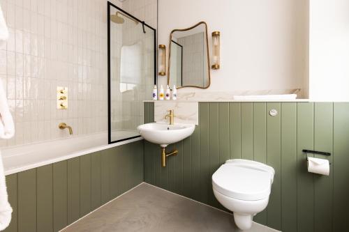 a bathroom with a white toilet and a sink at Native Kings Wardrobe, St Pauls in London