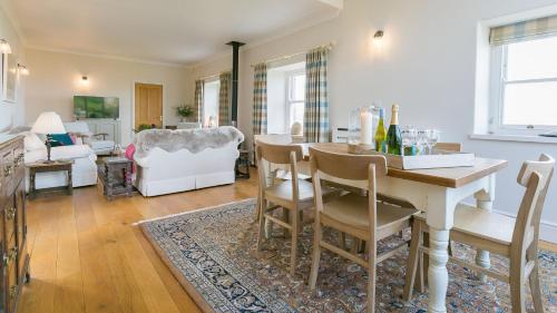a kitchen and living room with a table and chairs at Moryn in Moelfre