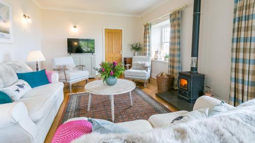 a living room with a couch and a wood stove at Moryn in Moelfre