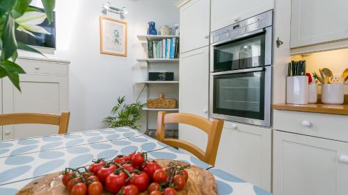a kitchen with a table with a bowl of tomatoes on it at Moryn in Moelfre
