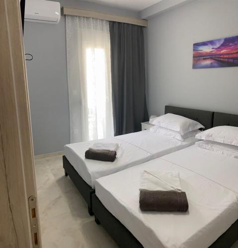 a bedroom with two beds with towels on them at Umbrella Apartment in Perea