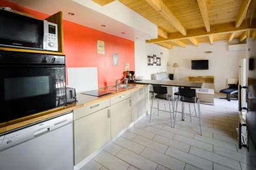 uma cozinha com armários brancos e electrodomésticos pretos em Maisonnette Cosy à Proximité de la Gare em Valence