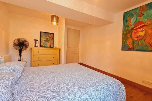 une chambre avec un lit et un tableau au mur dans l'établissement COOL BURGUNDY, à Beaune