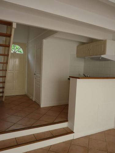 una habitación vacía con cocina y puerta en Petite maison avec jardin, en La Rochelle
