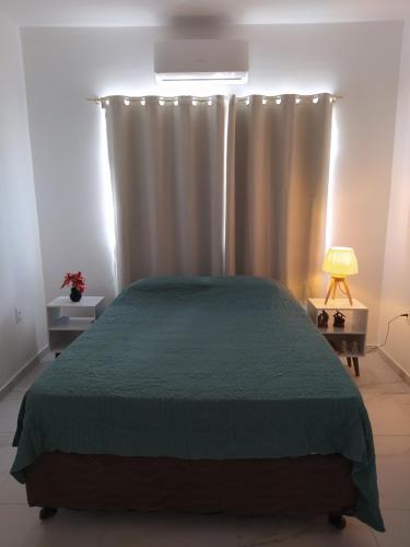 um quarto com uma cama com um edredão verde em Beach House Praia de Carapibus em Jacumã
