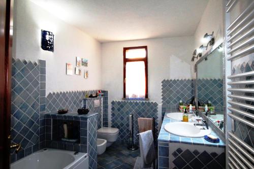 ein blau-weißes Badezimmer mit einem Waschbecken und einer Badewanne in der Unterkunft Villa Le Saline Ampia Vista Mare in Palau