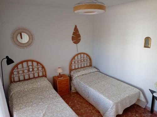 1 dormitorio con 2 camas y espejo en la pared en Nereidas Solo Familias SERVIPLAYA, en Casas Las Basas