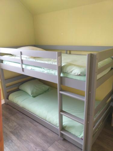 quelques lits superposés dans une chambre dans l'établissement Charmant logement calme de 35 m2, parking gratuit, à Folligny
