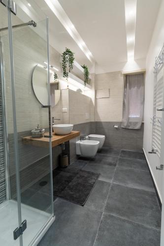 a bathroom with two toilets and a glass shower at L'Onda Affittacamere in Civitavecchia