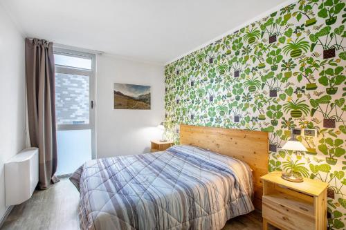 a bedroom with a bed and a green wall at Alpen Pila Residence Loft 5 in Aosta