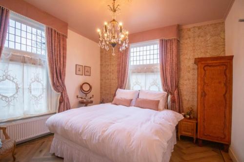 a bedroom with a large white bed and windows at Hotellerie Het Wapen Van Athlone in De Steeg