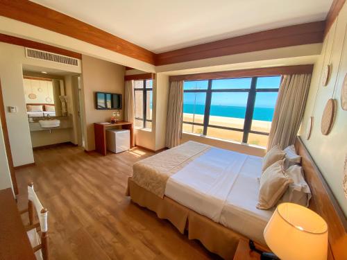 Schlafzimmer mit einem großen Bett und Meerblick in der Unterkunft Magna Praia Hotel in Fortaleza