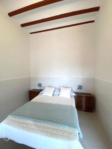 Casa Benicassim Completa في بنو قاسم: غرفة نوم بيضاء بسرير وليلتين