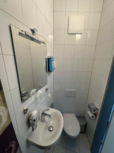 La salle de bains est pourvue d'un lavabo et de toilettes. dans l'établissement Angel Hotel, à Francfort-sur-le-Main