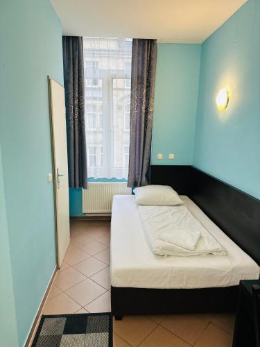 a bedroom with a bed in a blue room at Angel Hotel in Frankfurt