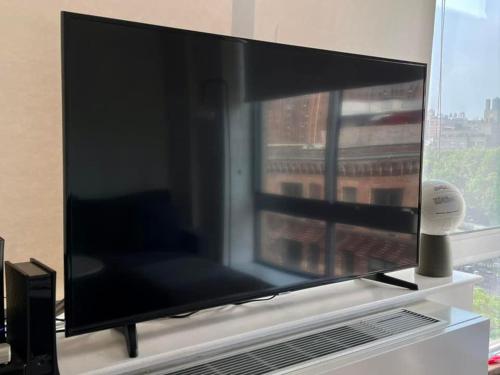 a large flat screen tv sitting on top of a window at 2 bedrooms Chelsea apartment - Manhattan in New York