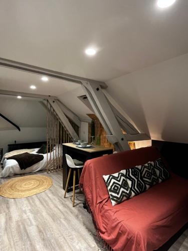 a room with a bed and a desk in a attic at Le Chalet Chic, Cosy avec Sauna au Centre Ville in Troyes