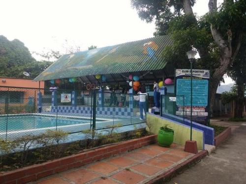 een zwembad met een gebouw naast een zwembad bij Mahanaim Centro Campestre de Eventos in Mariquita