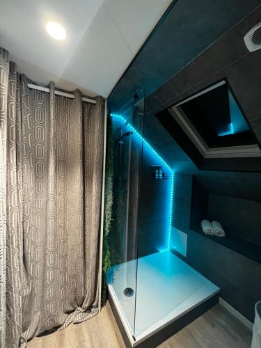 a bathroom with a shower with blue lights in it at Le Chalet Chic, Cosy avec Sauna au Centre Ville in Troyes