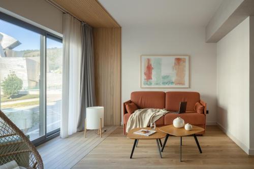 een woonkamer met een bank en een tafel bij Apartamentos Líbere Bilbao Museo in Bilbao