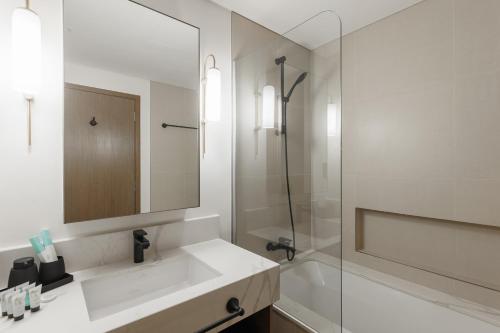a white bathroom with a sink and a shower at Burj Khalifa View & Creek lagoon in Dubai