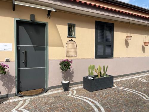 ナポリにあるMasseria Micheleの黒い扉と植物のある家