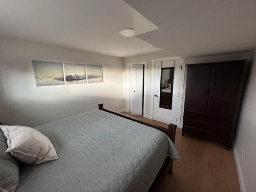 a bedroom with a bed and two pictures on the wall at Renovated 2 Bedroom Suite w/ King Bed in Kamloops
