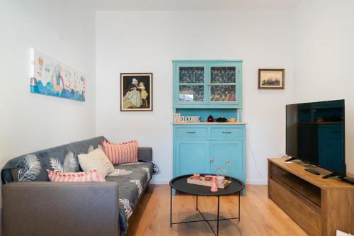 uma sala de estar com um sofá e uma televisão em The granny’s house em Kiáton