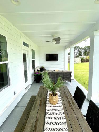 a porch with a wooden bench and a television on it at Emerald Oasis at Laguna Haven in Panama City Beach