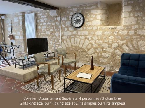 a living room with chairs and a clock on a wall at Le Pigeonnier centre historique Auxerre in Auxerre