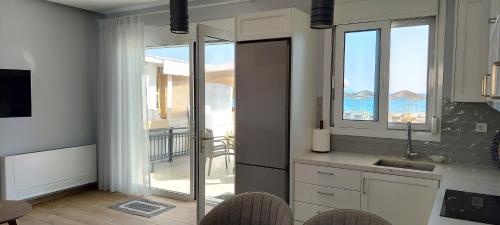 uma cozinha com uma varanda com vista para o oceano em Beachfront Bliss em Kardamaina