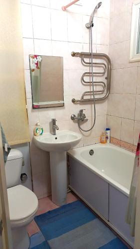 a bathroom with a sink and a tub and a toilet at Apartment - Generala Petrova Street in Odesa