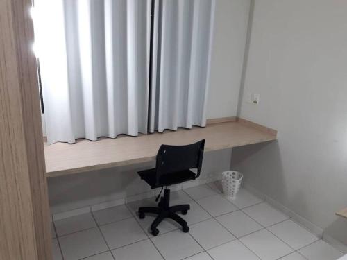 une chaise noire assise dans une pièce avec fenêtre dans l'établissement Flat para temporada Caruaru, à Caruaru