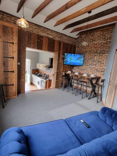 a living room with a blue couch and a dining room at Apartment 3 The Old Drill Hall in Ryde