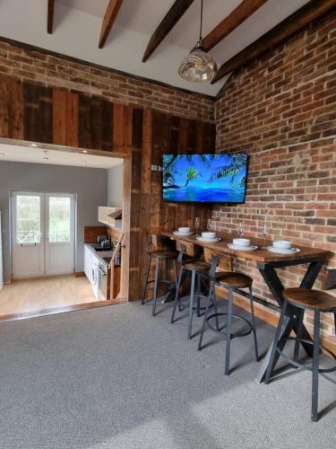 a dining room with a brick wall and a tv at Apartment 3 The Old Drill Hall in Ryde