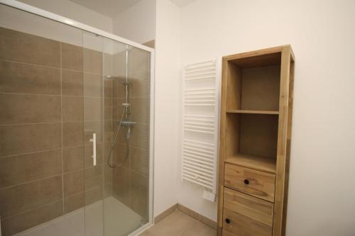 La salle de bains est pourvue d'une douche et d'une cabine de douche en verre. dans l'établissement Appartement 2 chambres, vue mer et parking, à Canet