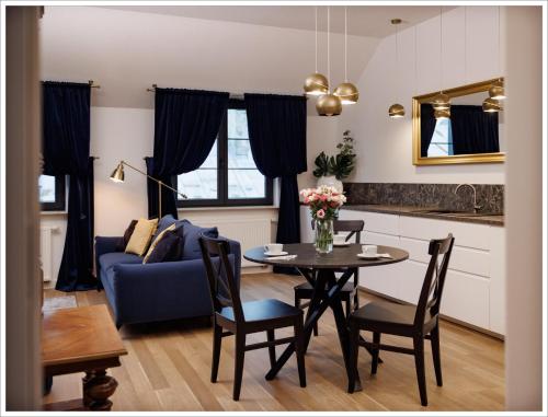 a living room with a table and a blue couch at Apartament przy Synagodze in Zamość