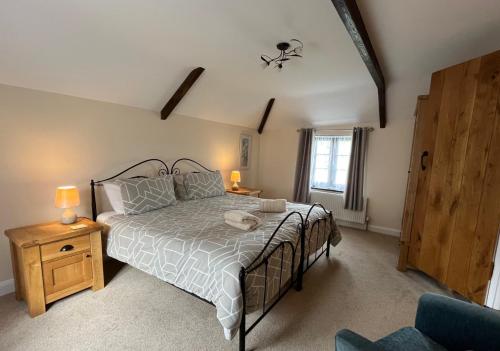 a bedroom with a large bed and a window at Maple & Beech Barns in Truro