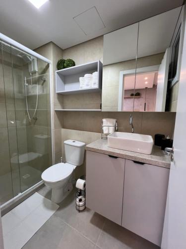 a bathroom with a toilet and a sink and a shower at Apartamento/Studio Novo Hamburgo in Novo Hamburgo