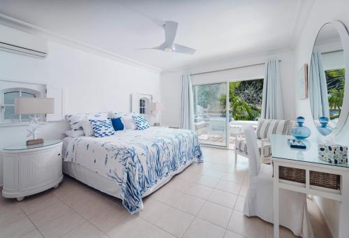 a white bedroom with a bed and a table and chairs at Sea View - Glitter Bay in Saint James