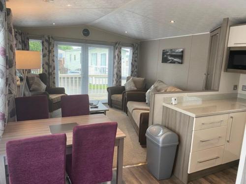 a living room with a couch and a table at 2 Bed Lodge Style Caravan with Hot Tub & Private Garden in Patrington