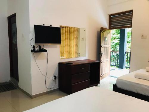 ein Schlafzimmer mit einem Bett und einem TV an der Wand in der Unterkunft Yala Freedom Lodge in Tissamaharama