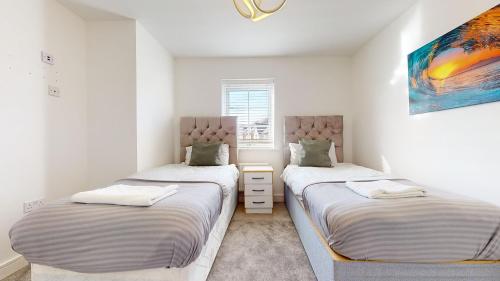 Habitación con 2 camas individuales y paredes blancas. en Tms Lovely 5-Bed House in Stanford-le-Hope, en Stanford-le-Hope