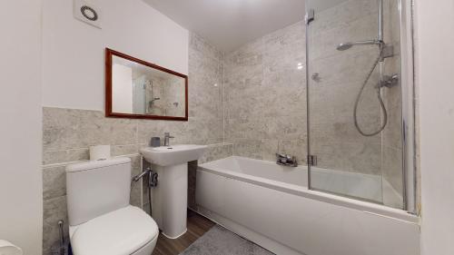 a bathroom with a toilet and a sink and a shower at Tms Lovely 5-Bed House in Stanford-le-Hope in Stanford-le-Hope