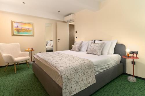 a hotel room with a bed and a chair at Villa Kiki in Podstrana