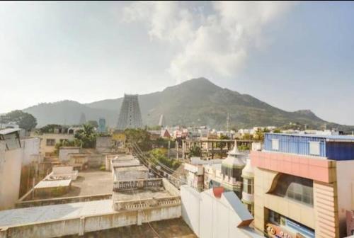 uitzicht op een stad met een berg op de achtergrond bij HOTEL SIVA SAKTHI in Tiruvannamalai