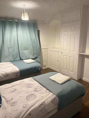 1 dormitorio pequeño con 2 camas y puerta en Tms 3bdr Tilbury - Free Parking, en Tilbury