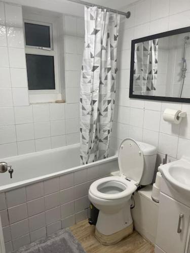 a white bathroom with a toilet and a sink at Tms 3bdr Tilbury - Free Parking in Tilbury