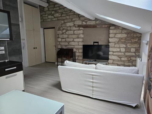 sala de estar con sofá blanco y TV en Casa Laura - Riva del Garda, en Riva del Garda